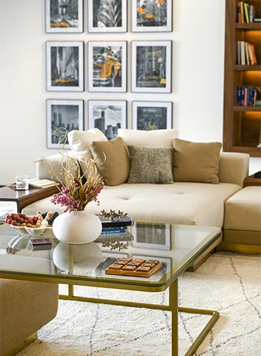 A beautifully arranged interior with a floral centerpiece, elegant frames adorning the walls, and a stylish tea table