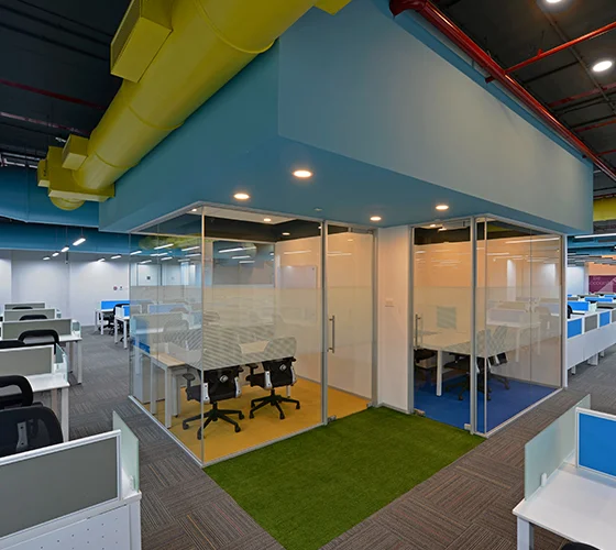 An office environment showcasing lively, colorful walls paired with a soothing blue ceiling, promoting a cheerful work setting.