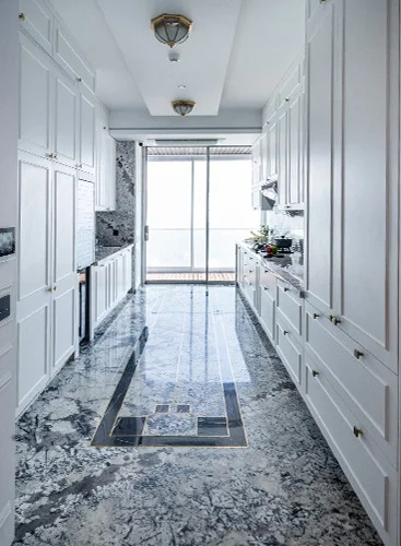 a sleek marble floor in a kitchen, paired with pristine white cabinets, enhancing the space's contemporary and clean aesthetic.