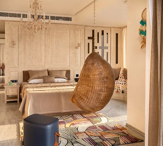 aesthetic bedroom interior featuring a bed, a swing, and a hanging chandelier.