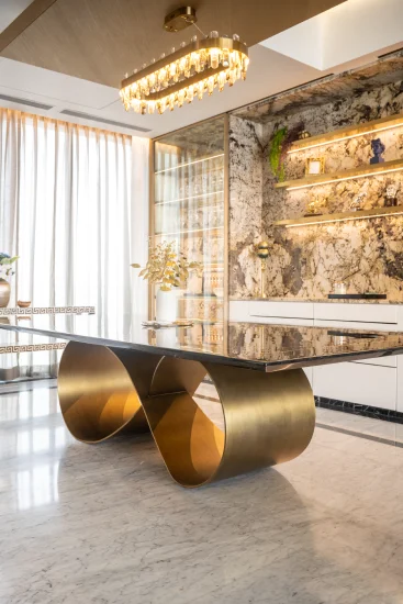 a sophisticated dining area with a gleaming gold table at its center, enhanced by modern furnishings and decor accents.