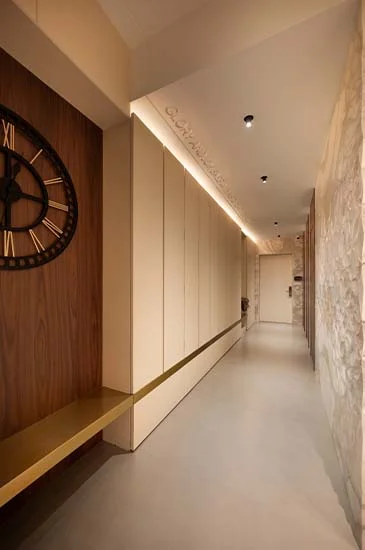 A hallway featuring a wall clock, emphasizing the passage of time in a serene indoor setting.