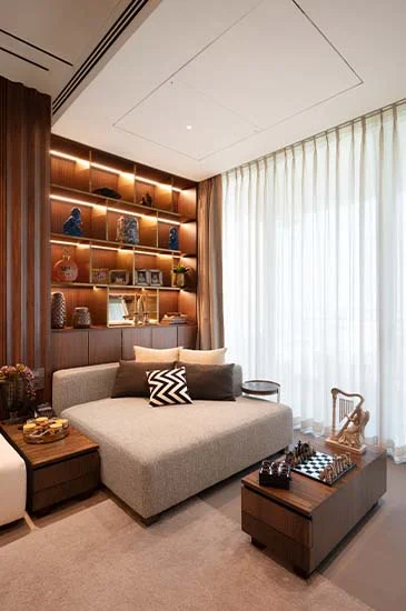 A contemporary living room featuring a stylish couch and a well-organized bookshelf filled with books.