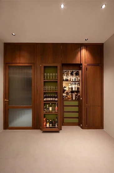A stylish room featuring a wine cabinet and a refrigerator, showcasing an elegant and functional design for beverage storage.