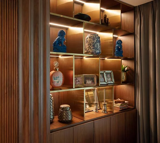 A room featuring a wooden shelf adorned with a decorative vase, creating a warm and inviting atmosphere.