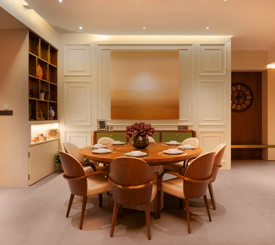 Luxury Interior Designer A dining room featuring a round table surrounded by elegant chairs, creating a warm and inviting atmosphere.