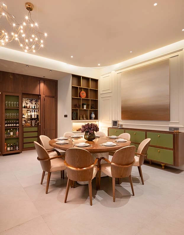 Luxury Interior Designer A dining room featuring a round table surrounded by elegant chairs, creating a warm and inviting atmosphere. 7Nirvana