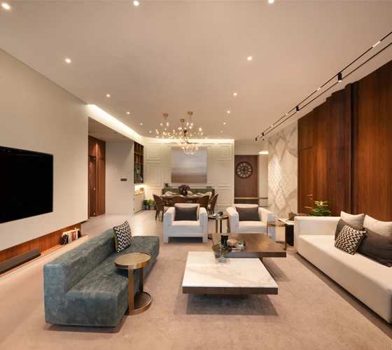 Luxury Interior Designer in Mumbai and UAE 7Nirvana A contemporary living room featuring a spacious layout and a large television as the focal point of the design.