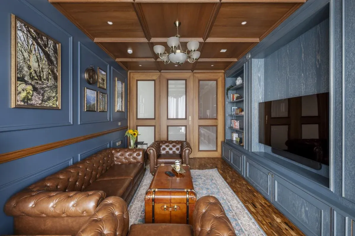 Den at The Colonial Home by 7Nirvana, with leather Chesterfield sofas, blue panelled walls and a teak-coffered ceiling