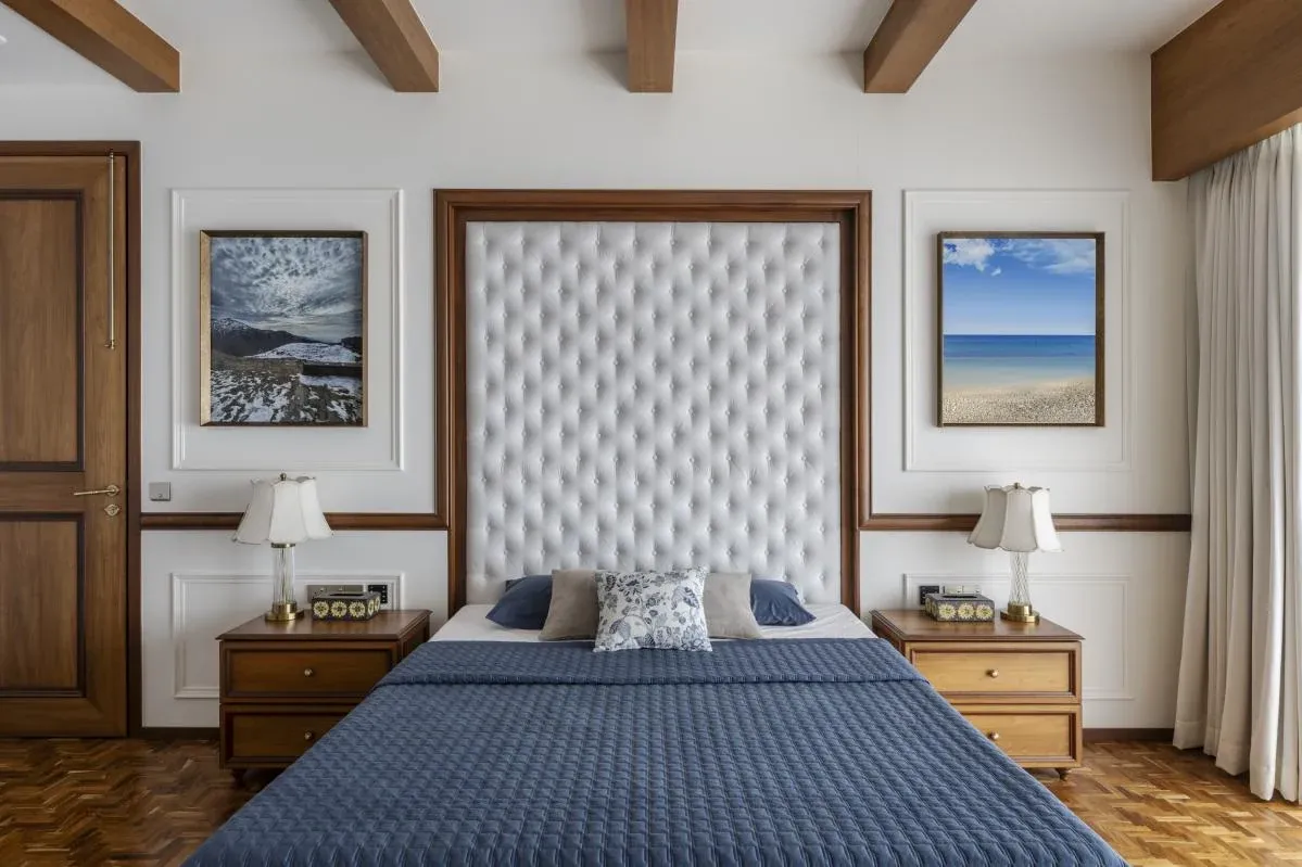 Bedroom at The Colonial Home by 7Nirvana, with a tufted headboard, exposed wooden beams and framed sea photography